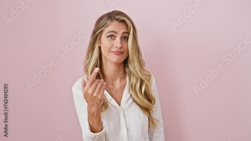 Blonde beauty spilling gossip, young woman in pink, whispering bad news with hand over mouth, standing isolated, voicing malicious chatter photo