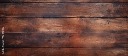 A closeup of a rectangular brown hardwood plank table with a beautiful wood grain pattern and amber wood stain. The blurred background adds to the allure of the flooring