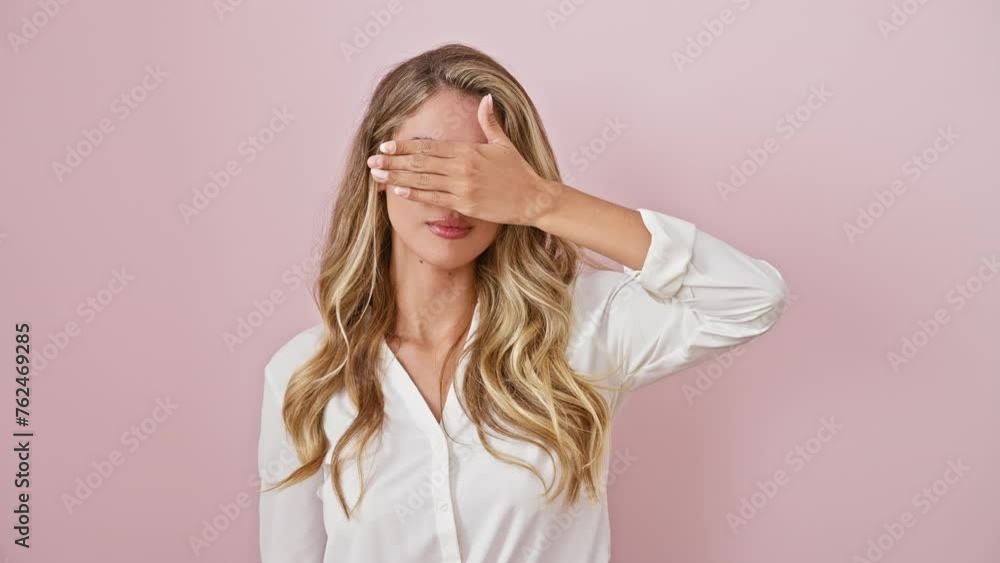 Sad young blonde woman, standing in pink isolated background, covering eyes with hand, wearing shirt - a sightless, hiding, rejection concept over her serious expression. Sad young blonde woman, standing in pink isolated background, covering eyes with hand, wearing shirt - a sightless, hiding, rejection concept over her serious expression.