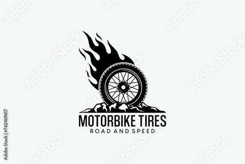 Vector illustration of a motorbike tire logo with fire on rocky ground. Automotive logo