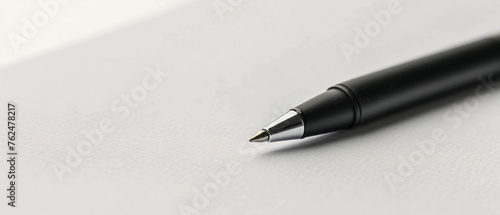 Elegant black pen poised on white paper, ready for words to flow on the page.