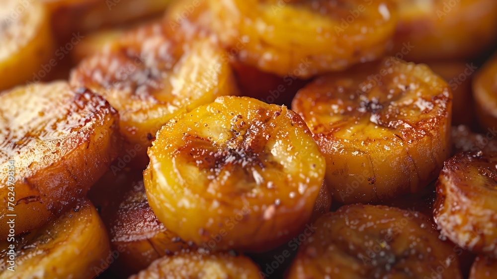 Close-up of caramelized golden fried plantains sprinkled with sugar