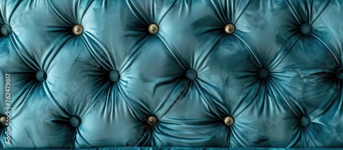 A closeup of a tufted couch resembling a cloud on a sunny day, with vibrant blue fabric and elegant gold buttons, reminiscent of the azure sky reflecting in water