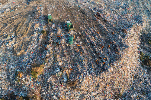 Aerial view of garbage pile in trash dump. Dump track unload waste at landfill. Biohazard for ecosystem and healthy environment concept. Environmental pollution and ecological disaster