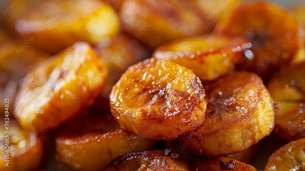Close-up of caramelized golden fried plantains sprinkled with sugar