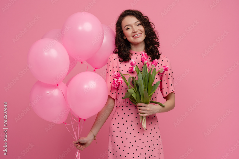 pretty young woman posing isolated on pink studio background with tulips flowers pretty young woman posing isolated on pink studio background with tulips flowers