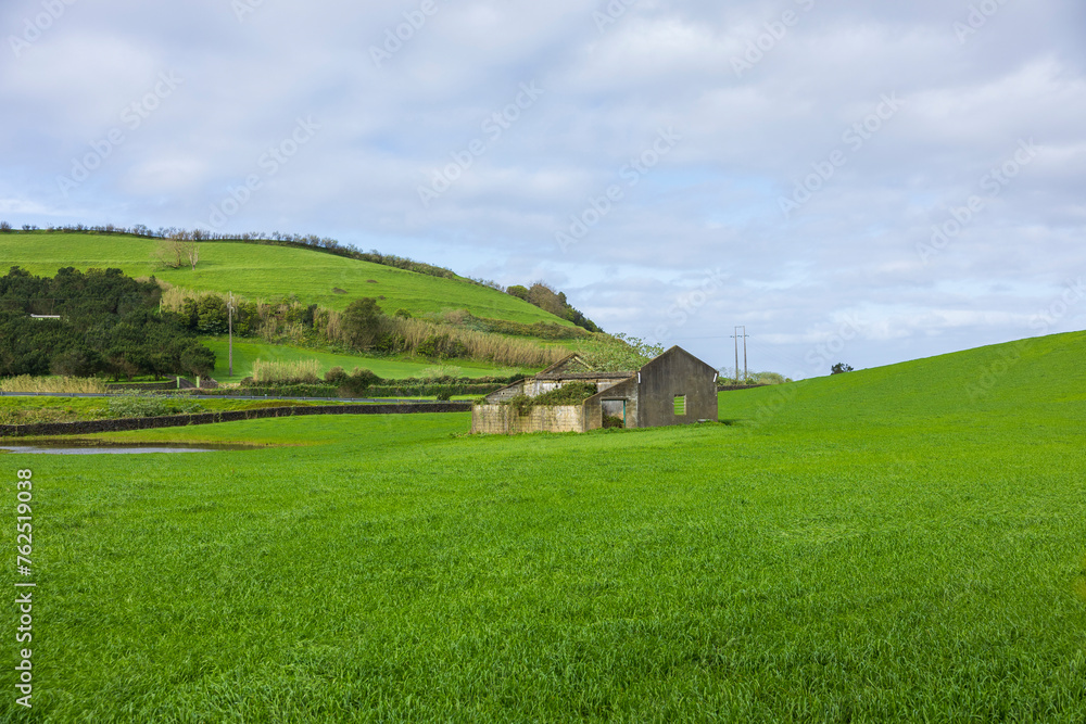 Rural landscape with green meadows and abandoned house. Sao Miguel Island, Azores