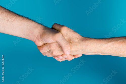 Photo of two senior female young male arms shacking hands signing care contract isolated blue color background