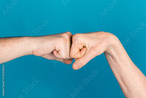 Photo of two senior female young male arms bumping fists greeting isolated blue color background