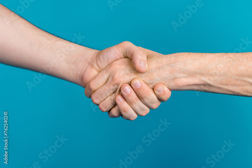Photo of two mature young people arms palms shacking hands showing partnership isolated blue color background