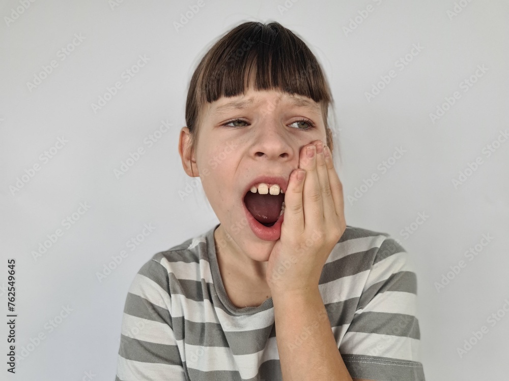 Beautiful young girl kid on white table touching mouth with hand with painful expression because of toothache Beautiful young girl kid on white table touching mouth with hand with painful expression because of toothache