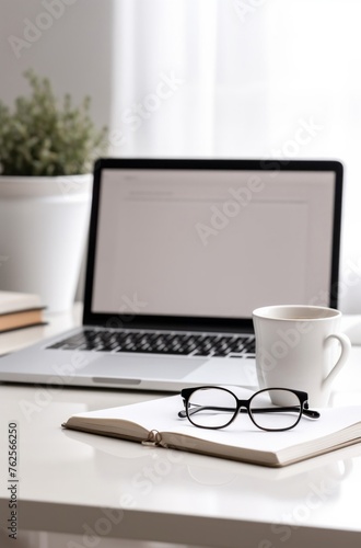 Focused Productivity: Open Laptop with Notebook, Glasses, and Coffee