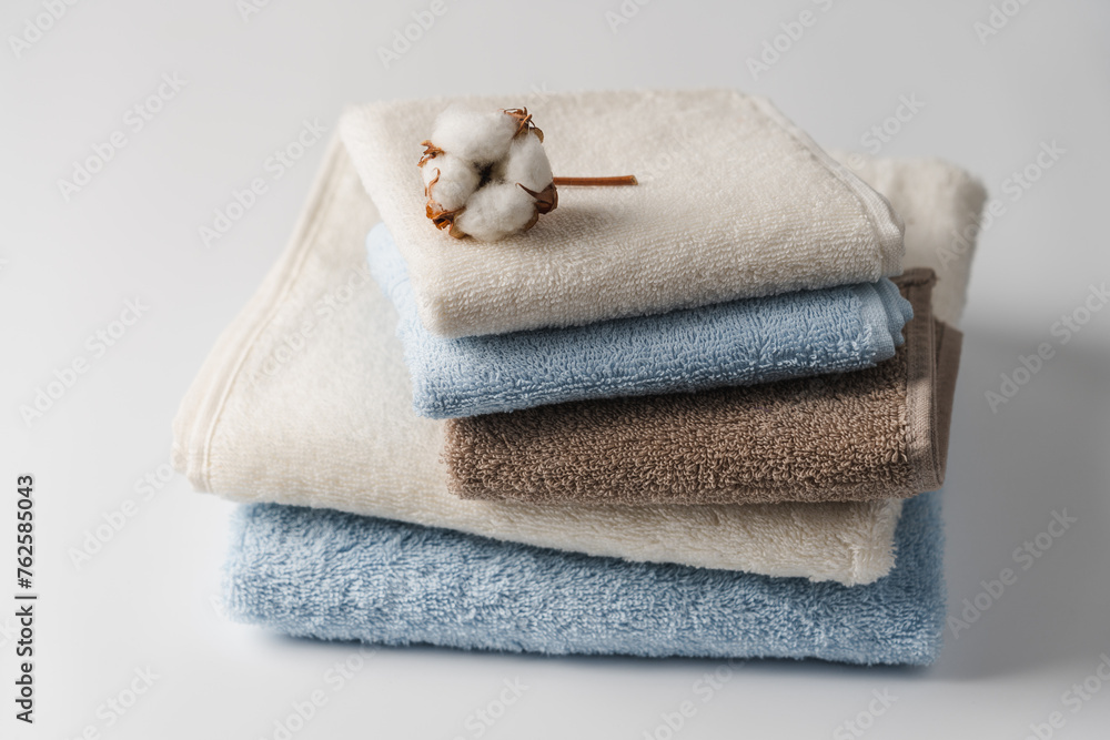 Stack of delicate colored cotton towels with cotton buds on white background Stack of delicate colored cotton towels with cotton buds on white background