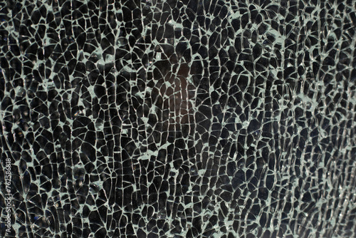 Small cracks on the glass. Texture of broken glass. Lots of chaotic fragments.