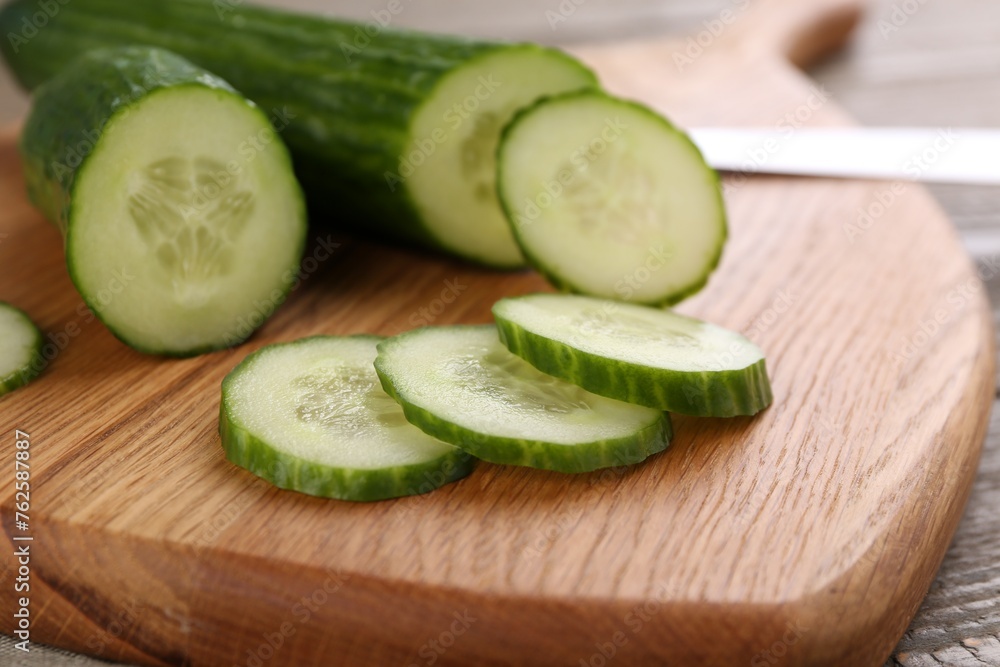 Fresh cucumbers on wooden cutting board, closeup Fresh cucumbers on wooden cutting board, closeup