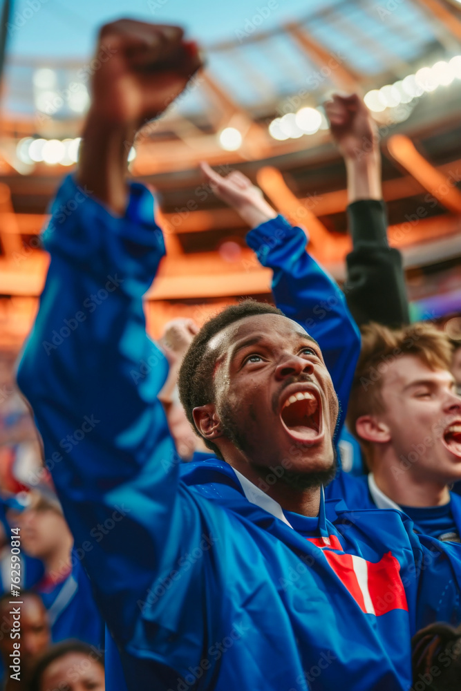 Cheering French football fans at the stadium. Close-up portrait of a group of football fans on the background of the stadium.
Cheering French football fans at the stadium. Close-up portrait of a group of football fans on the background of the stadium.