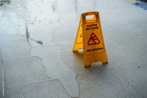 wet floor sign with the words caution wet floor, the terrace floor is wet because of the rain