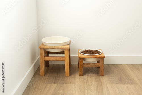 Dog feeding bowls on wooden stand. Water and biscuit pet food modern home corner