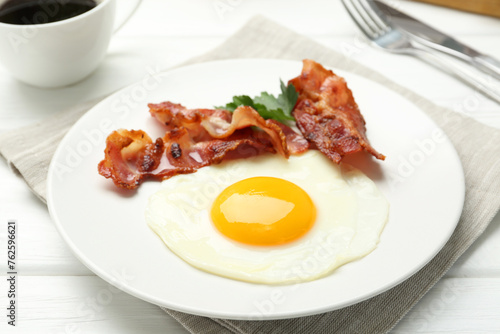 Delicious breakfast with sunny side up egg on white wooden table, closeup