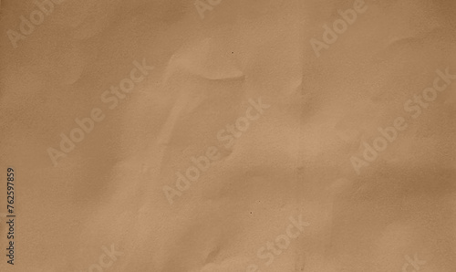close up crumpled brown kraft paper background showing crease texture with blank space for design. flat crumpled cardboard brown paper with grain texture.