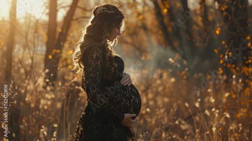 A beautiful pregnant woman dressed in a black lace dress accentuating her figure