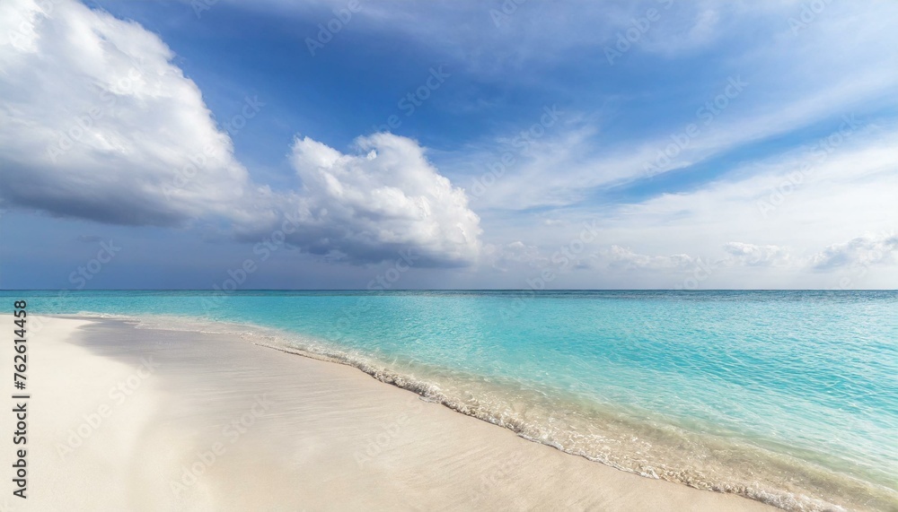 Beautiful sandy beach with white sand and rolling calm wave of turquoise ocean on Sunny day