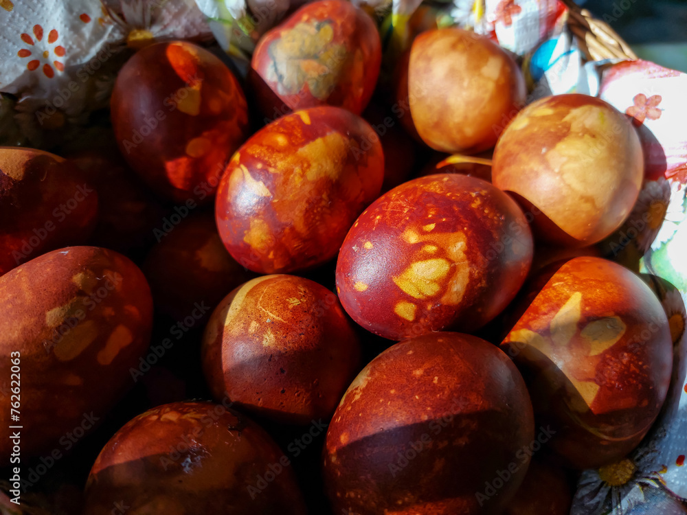 Obraz premium Macro shot of Easter eggs decorated with natural plants and flower blossoms boiled in onions peels. Traditional way to create yellow patterns of plants on brown eggs