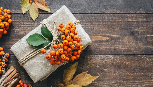 autumn gift with rowan wrapped in fabric on brown rustic background a traditional furoshiki gift top view flat lay copy space