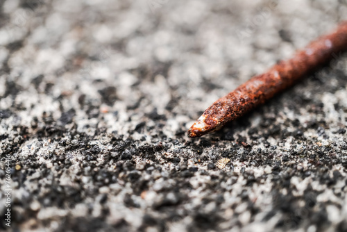 Old rusty nail laid on rough cement wall surface. Empty blank copy text space photo