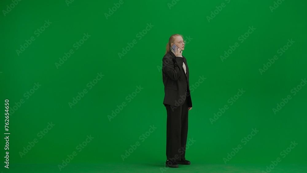 Women in business suit on green screen with chroma key. Blonde business woman talking on smart phone. Side view. Women in business suit on green screen with chroma key. Blonde business woman talking on smart phone. Side view.