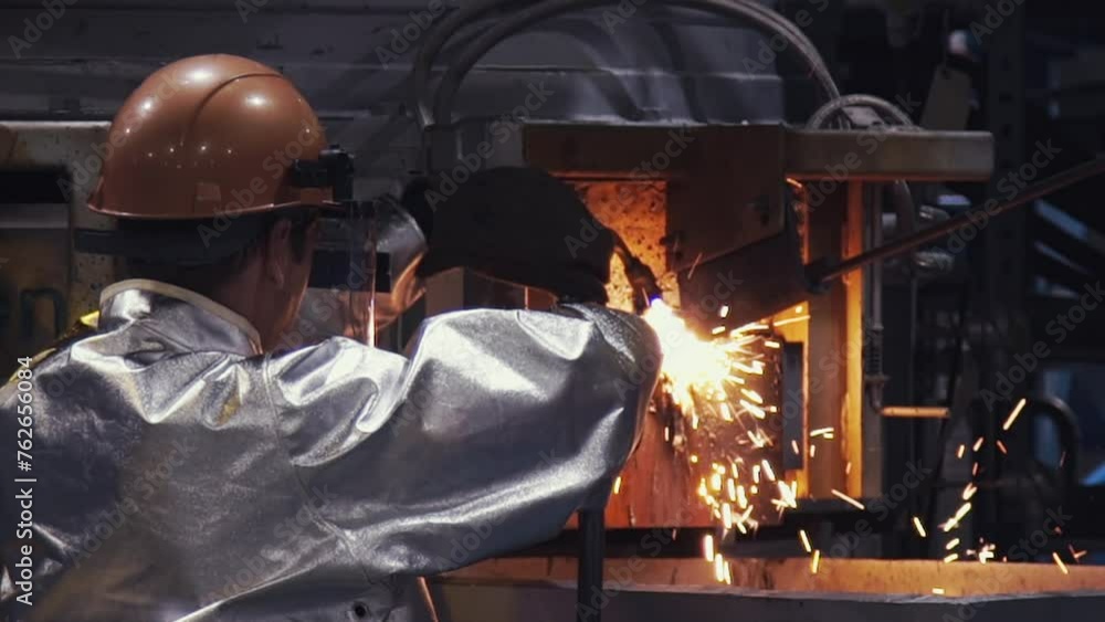Male Worker In Protective Uniform Using Welding Torch At A Metallurgy Factory. Industrial Welding Torch Worker In Steel Making Production Process. Welding Torch Worker Manually Fusing Metal Parts Male Worker In Protective Uniform Using Welding Torch At A Metallurgy Factory. Industrial Welding Torch Worker In Steel Making Production Process. Welding Torch Worker Manually Fusing Metal Parts