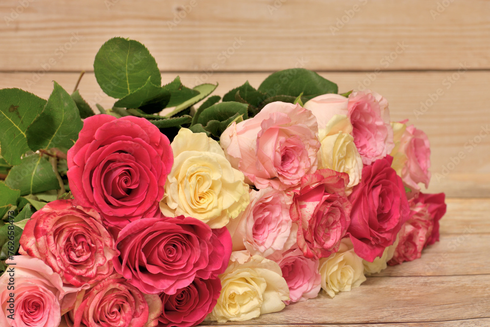 A bouquet of yellow and pink roses lies on the table A bouquet of yellow and pink roses lies on the table