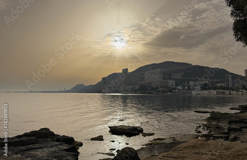 Hazy sky over the Mediterranean beach of Albufereta in Alicante, Spain, due to Sahara dust suspended in the air.
