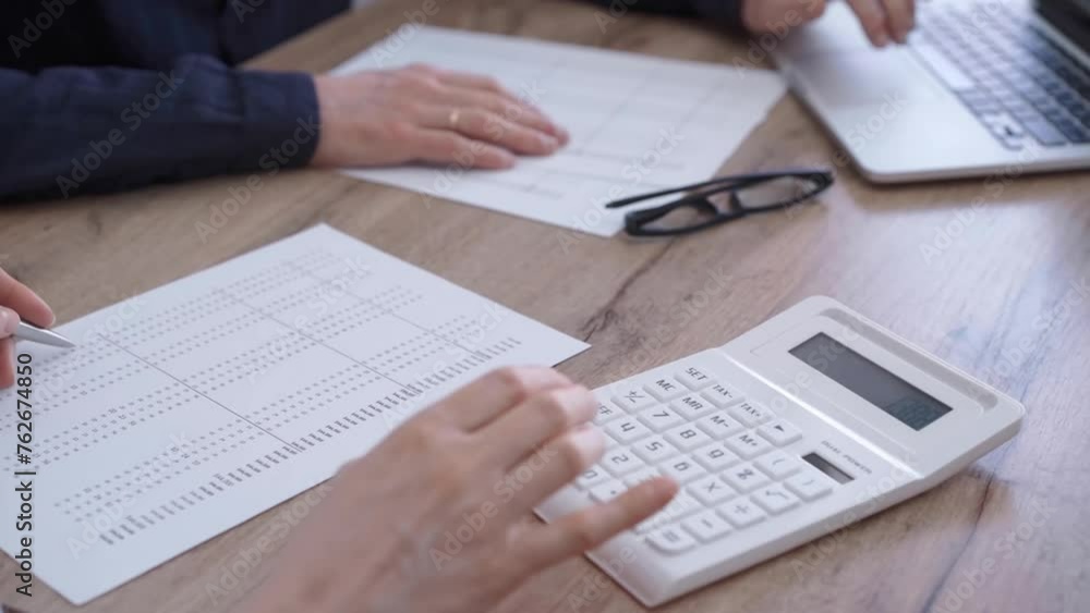Close up of professional hands using a calculator to conduct financial analysis and reporting for business accounting in a corporate office. Bookkeeping, finance audit and taxes Close up of professional hands using a calculator to conduct financial analysis and reporting for business accounting in a corporate office. Bookkeeping, finance audit and taxes