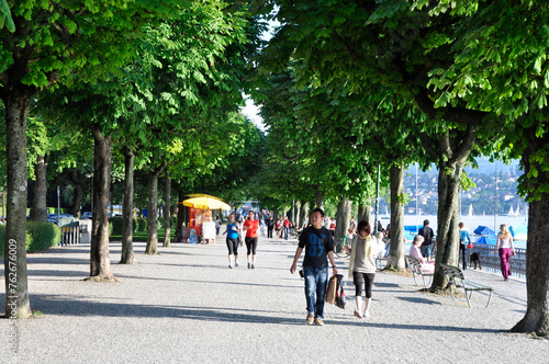 Spaziergängeram Zürichseeufer unter den Platanen der Baumallee beim Utoiquai, predestrians walking at the boarder of lake Zürich under the tree-Allee