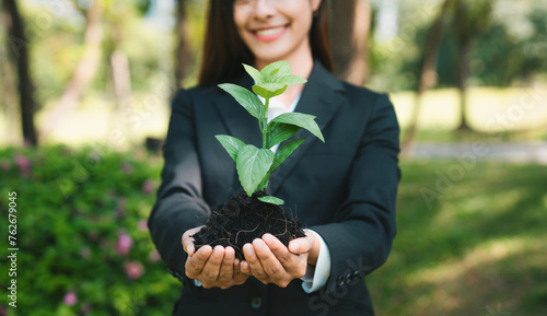 Asian businesswoman holding plant as concept of eco company committed to corporate social responsible, reducing CO2 emission, protect environment, and embrace ESG principle for sustainable future.Gyre photo