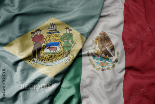 big waving realistic national colorful flag of delaware state and national flag of mexico .