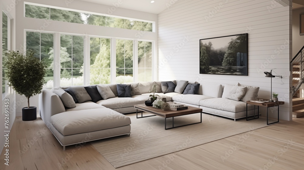 Fototapeta premium Light oak hardwood floors with a dark charcoal gray sectional and white shiplap walls.