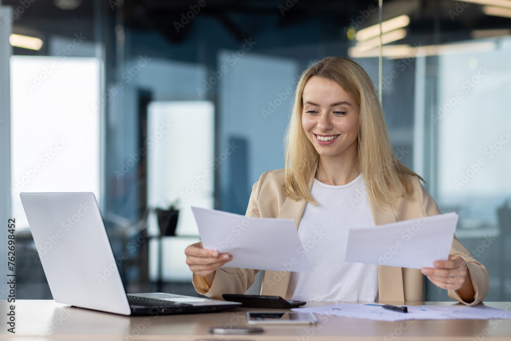 Professional woman reviewing documents in office setting Professional woman reviewing documents in office setting