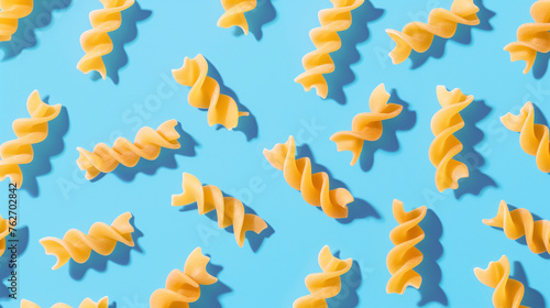 pattern of fusilli pasta on blue background, food concept, vegan food © PixelCharm