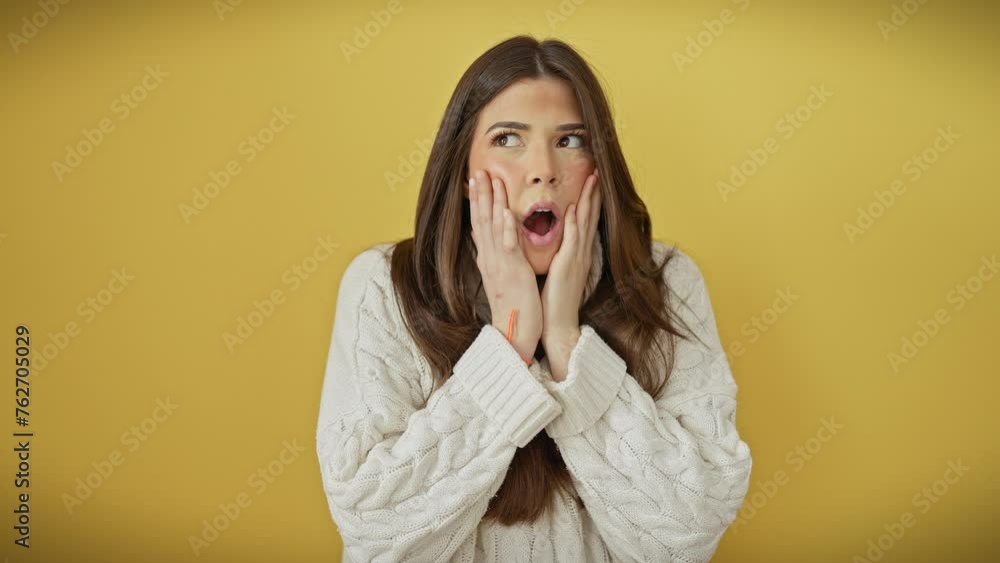 Young beautiful hispanic woman wearing sweater standing afraid and shocked, surprise and amazed expression with hands on face over isolated yellow background Young beautiful hispanic woman wearing sweater standing afraid and shocked, surprise and amazed expression with hands on face over isolated yellow background