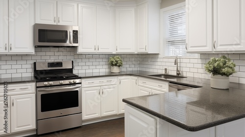 White kitchen cabinets with a black granite countertop and light gray subway tile backsplash.