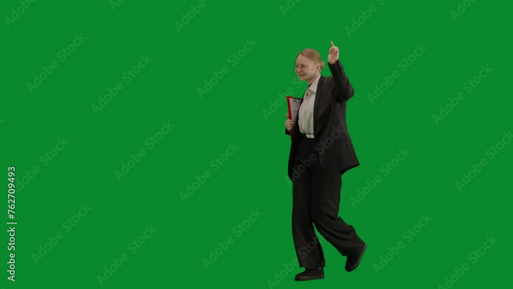 Portrait of female in suit on chroma key green screen. Blonde business woman in formal outfit walking and dancing, smiling positive expression. Half-turn. Portrait of female in suit on chroma key green screen. Blonde business woman in formal outfit walking and dancing, smiling positive expression. Half-turn.