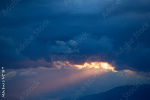垂れ込めた雲の間から差す夕方の光 photo