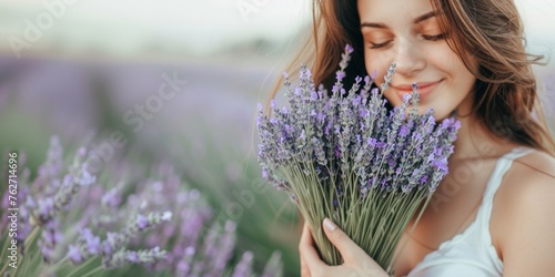 Woman holds a bouquet of freshly cut lavender, enjoying its delicate scent, banner with copy space.