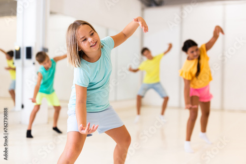Girl and other kids dancing hip hop in dance studio