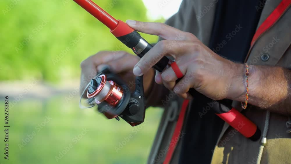 Fishing in nature with a man in a tourist robe. Men's hands hold a fishing rod. Fishing in nature with a man in a tourist robe. Men's hands hold a fishing rod.