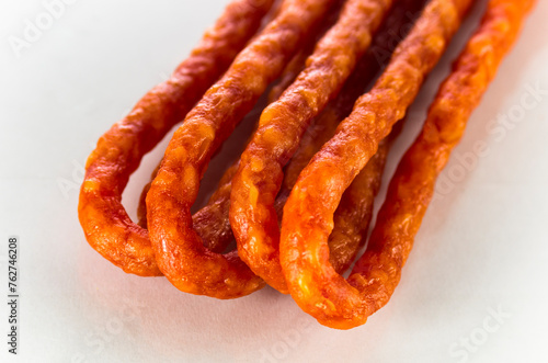 Many thin sausages on a white background
