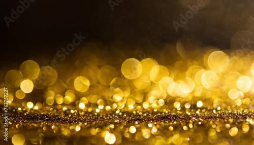 swirly bokeh of golden glitter shimmer dust dark abstract background
