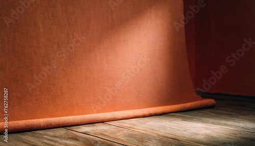 photo background is orange red textured wall rolling in the floor studio photography background illuminated by the directed light traditional painted canvas or muslin fabric cloth studio backdrop photo